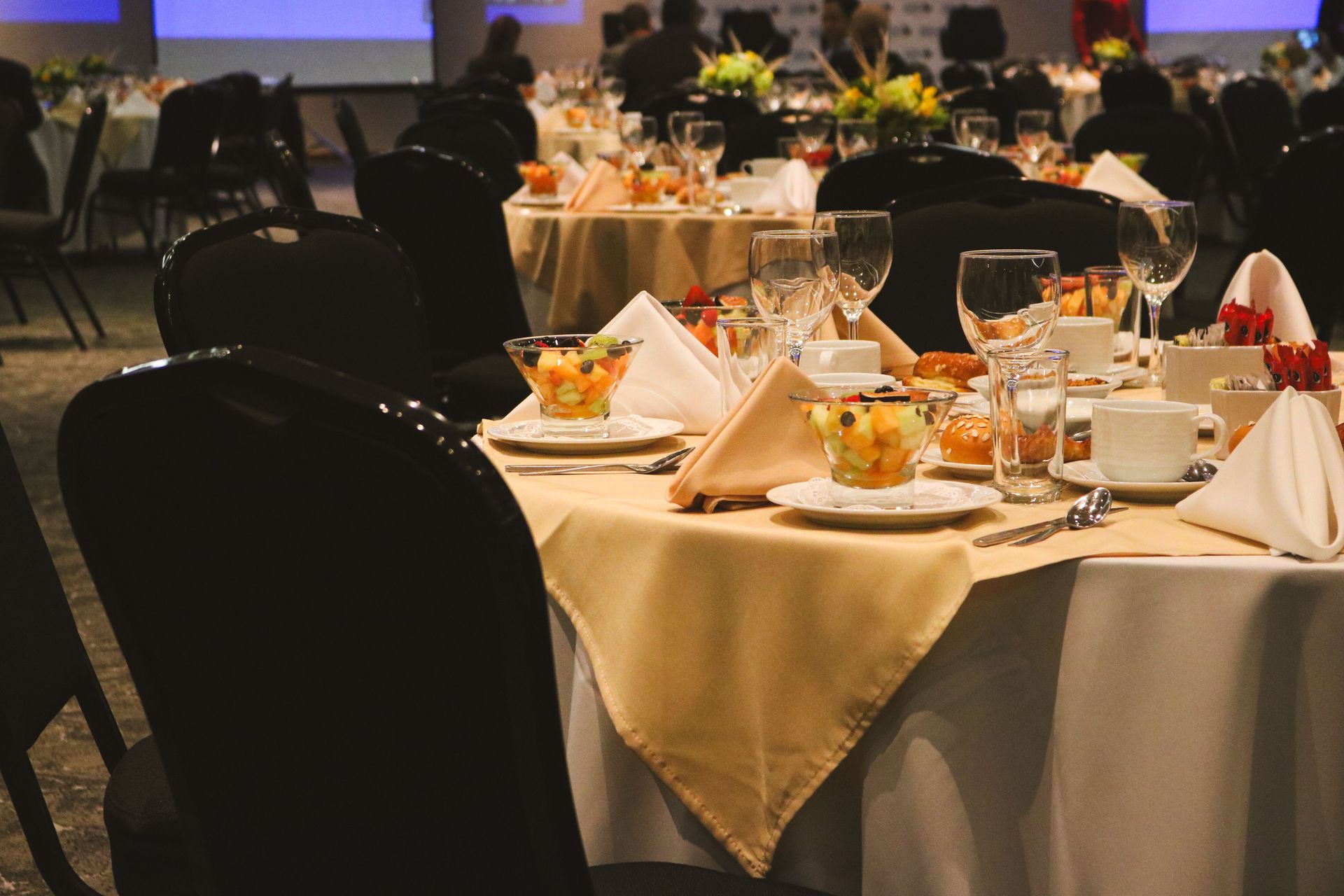 Beautiful table arrangement at an upscale restaurant featuring fruit salad and elegant dinnerware.