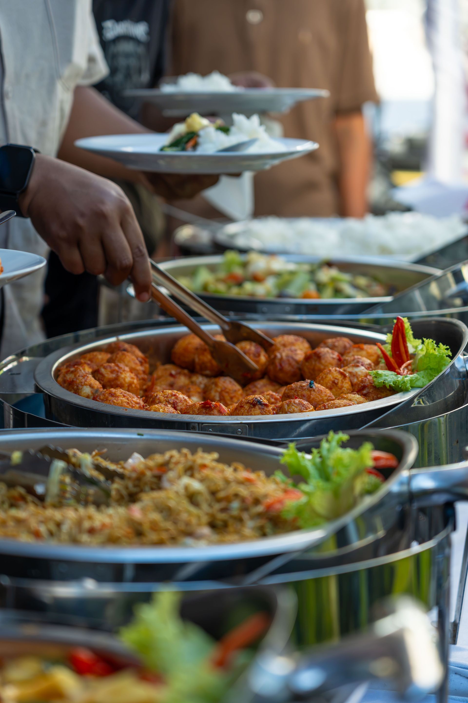 An appetizing buffet spread featuring various dishes at an outdoor event, highlighting culinary diversity.